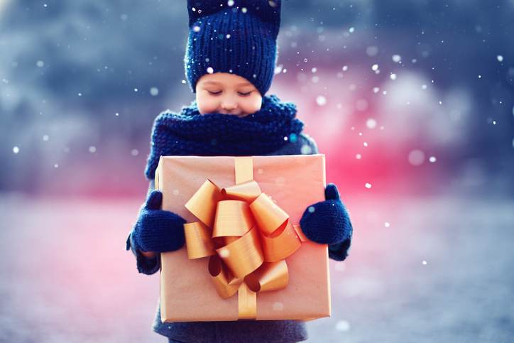 adorable kid with big gift box under a snowfall. Focus on gift box adorable kid with big gift box under a snowfall. Focus on gift box