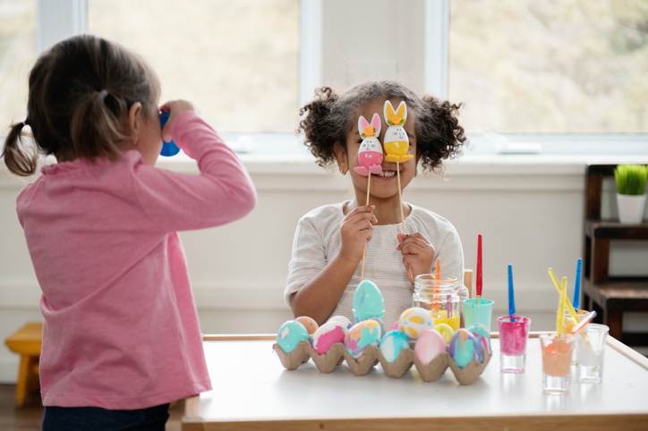 Two Little girls looking through Easter eggs.