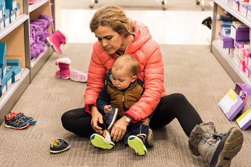 Mature woman shopping for shoes for her baby boy Mature woman shopping for shoes for her baby boy