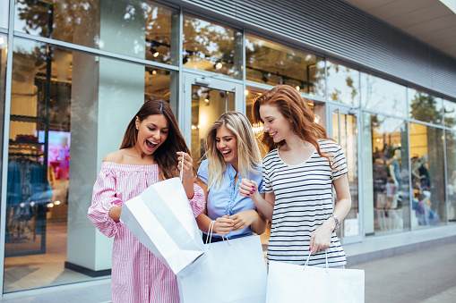 Photo of three satisfied young women shopping.